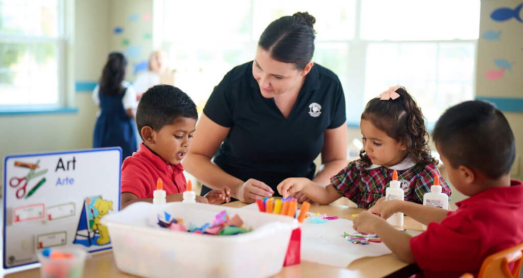 Primrose teacher guiding three students through an art activity
